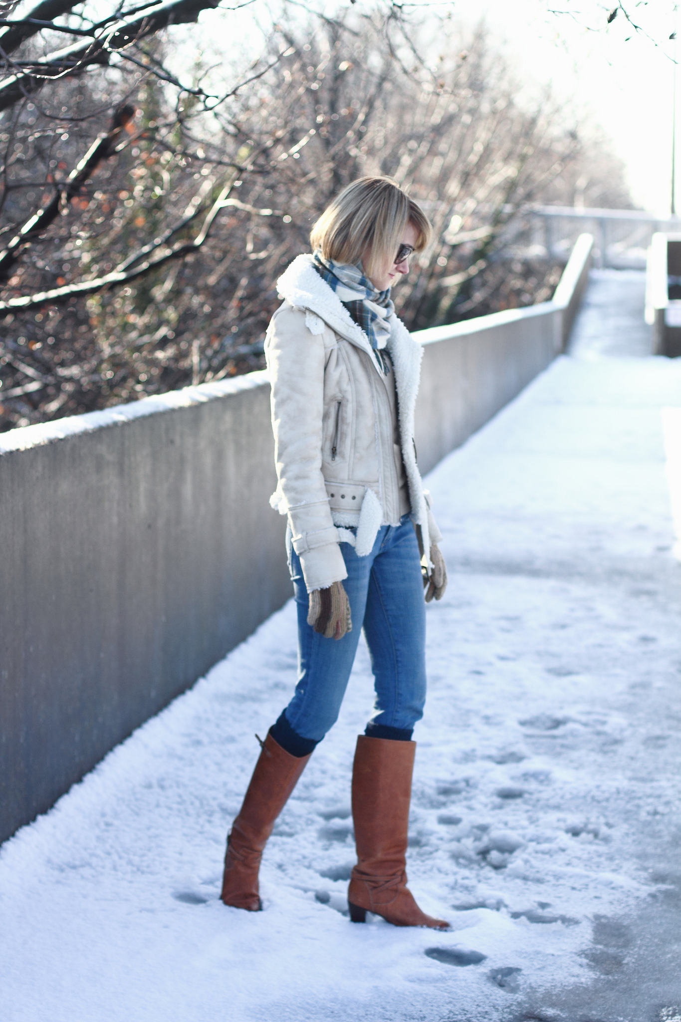 white shearling jacket and brown knee-high boots