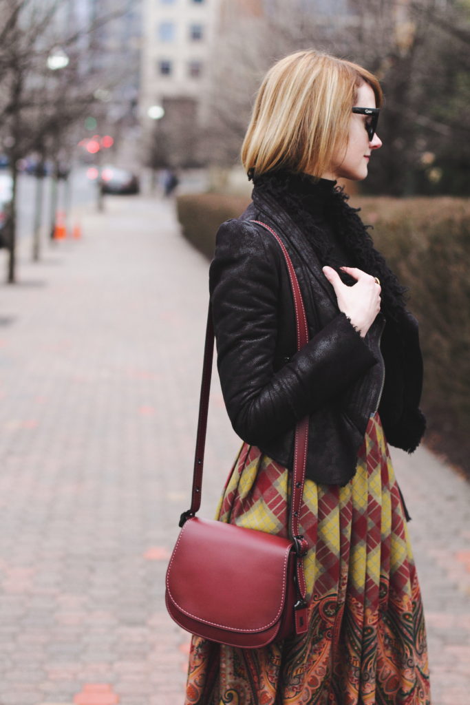 black turtleneck, leather jacket and Coach bag