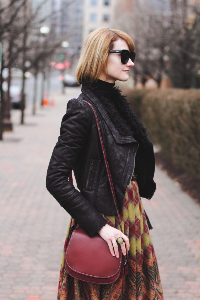 black turtleneck, leather jacket and Coach bag