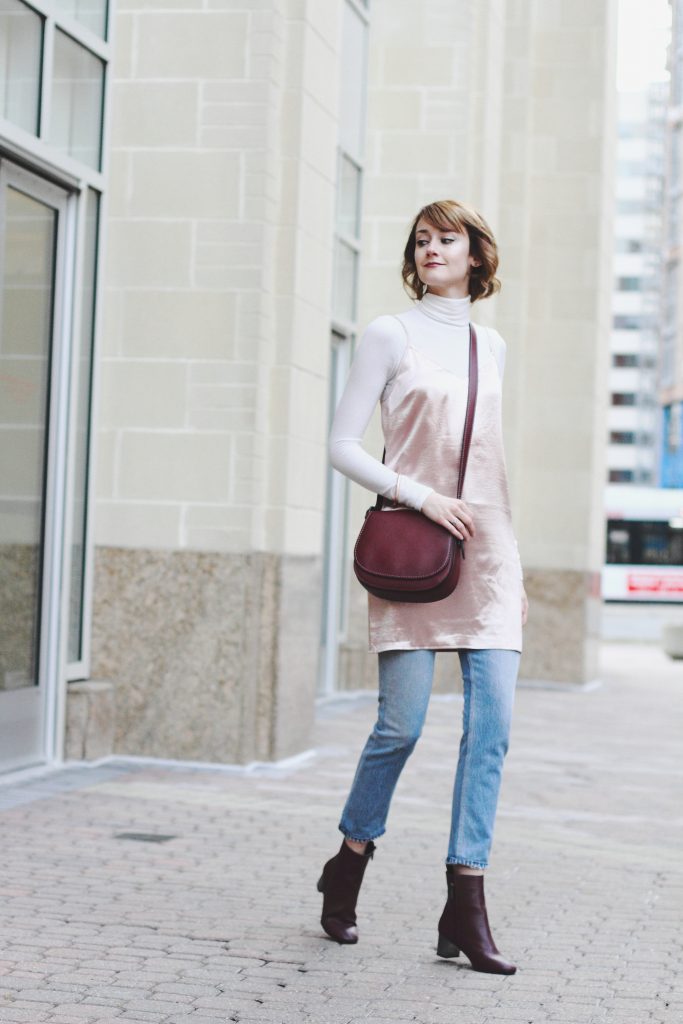 turtleneck, layering slip dress, jeans, and Coach bag