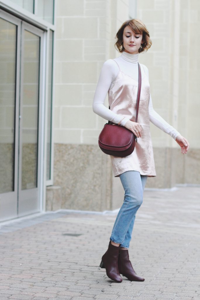 turtleneck, layering slip dress, jeans, and Coach bag