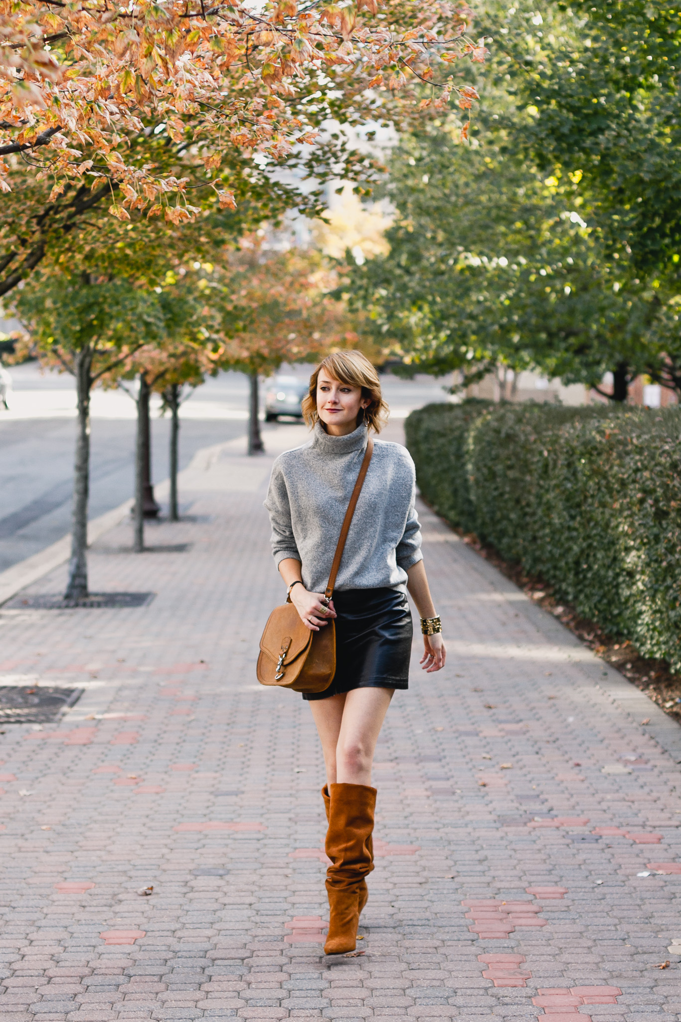 oversized sweater, leather skirt, and slouchy brown boots