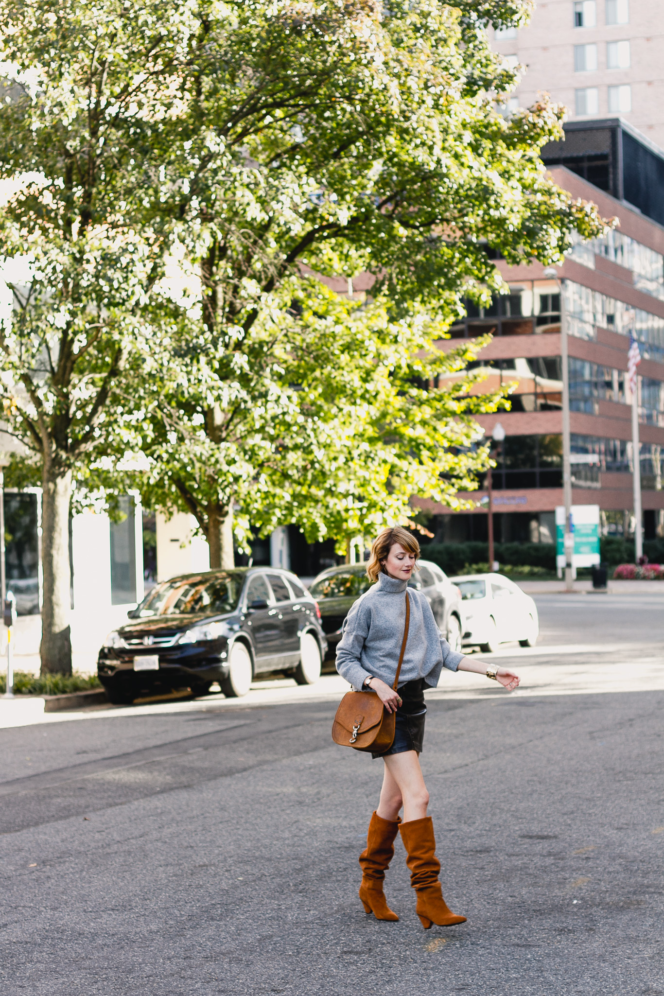 oversized sweater, leather skirt, and slouchy brown boots