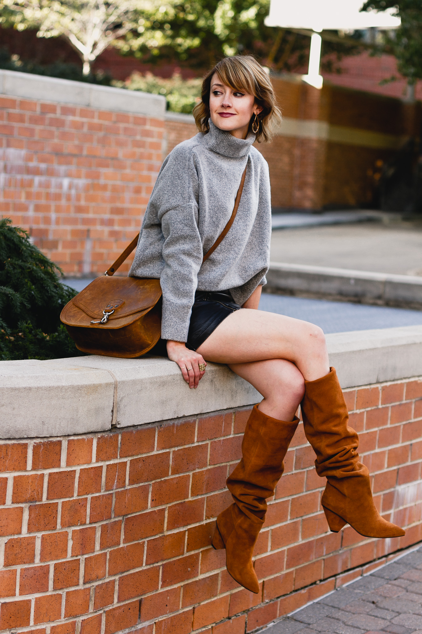 oversized sweater, leather skirt, and slouchy brown boots